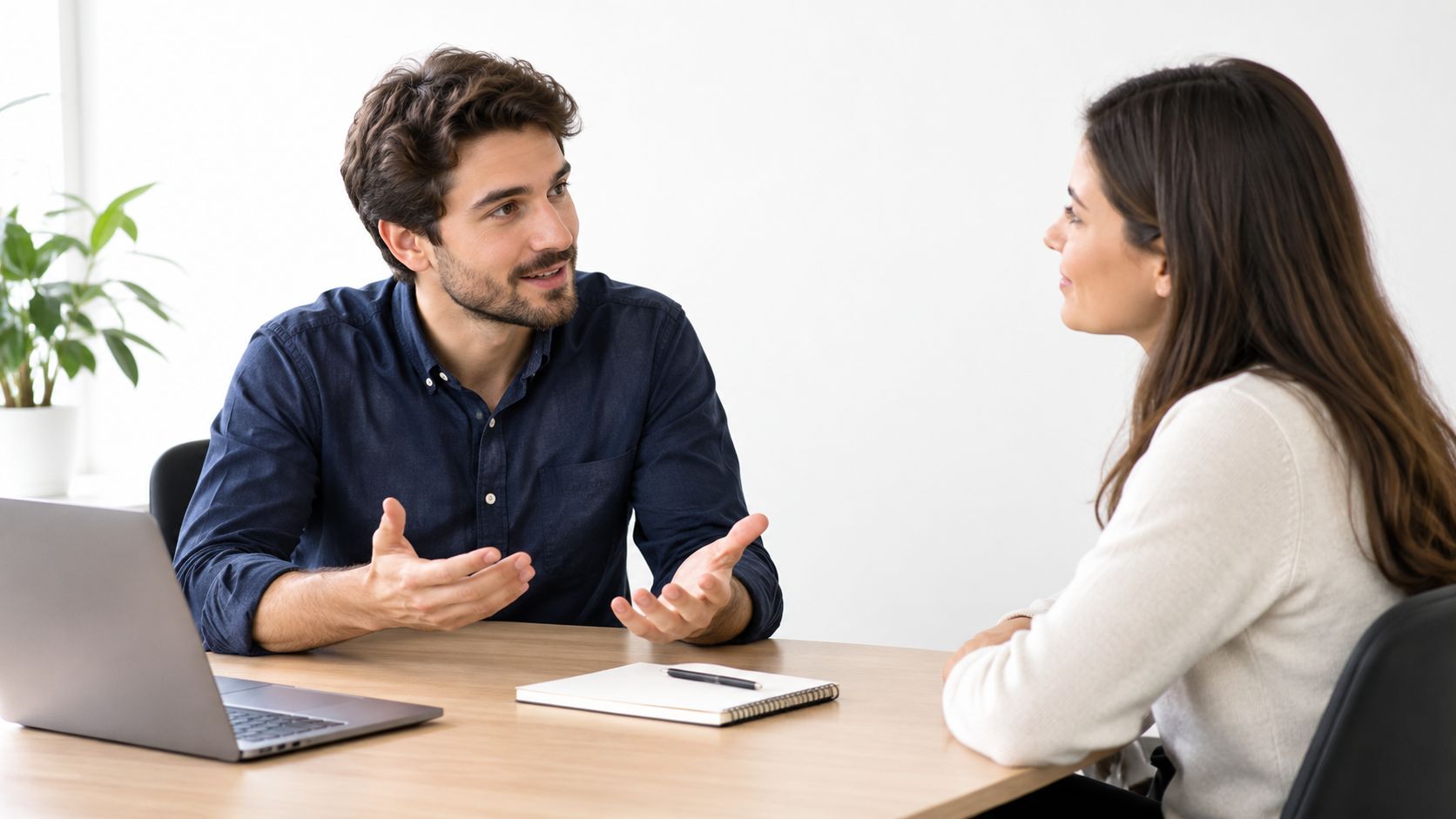 A professional man and woman having a productive conversation during a meeting in a bright office.