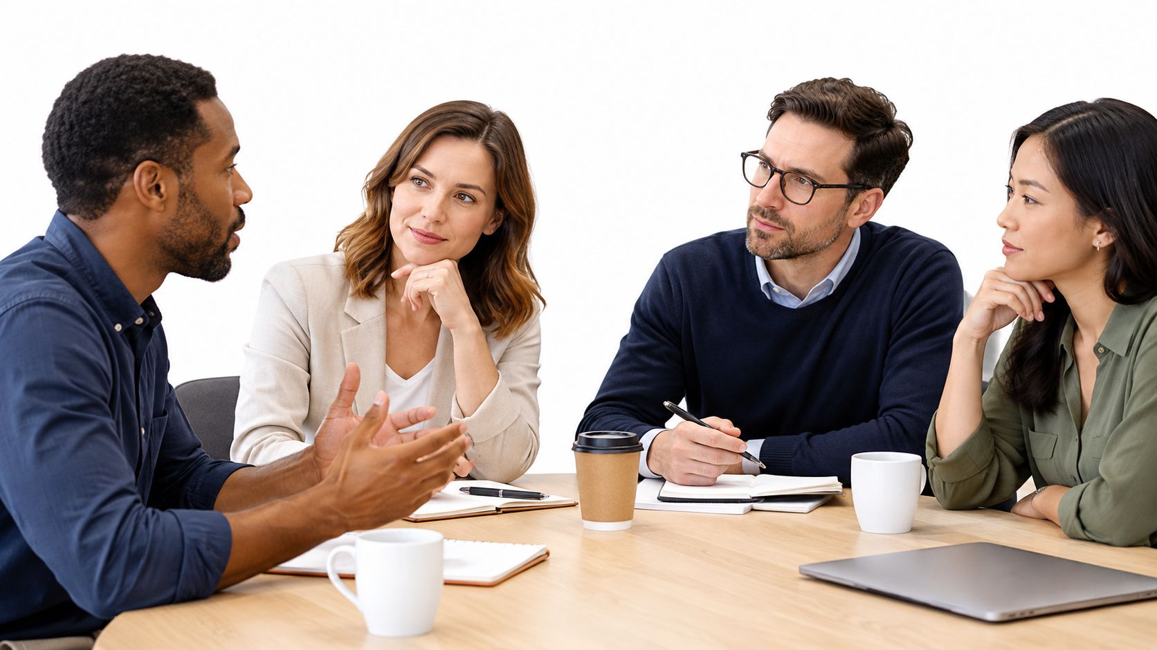 A diverse team of four professionals sitting at a round table, discussing business ideas during a meeting.