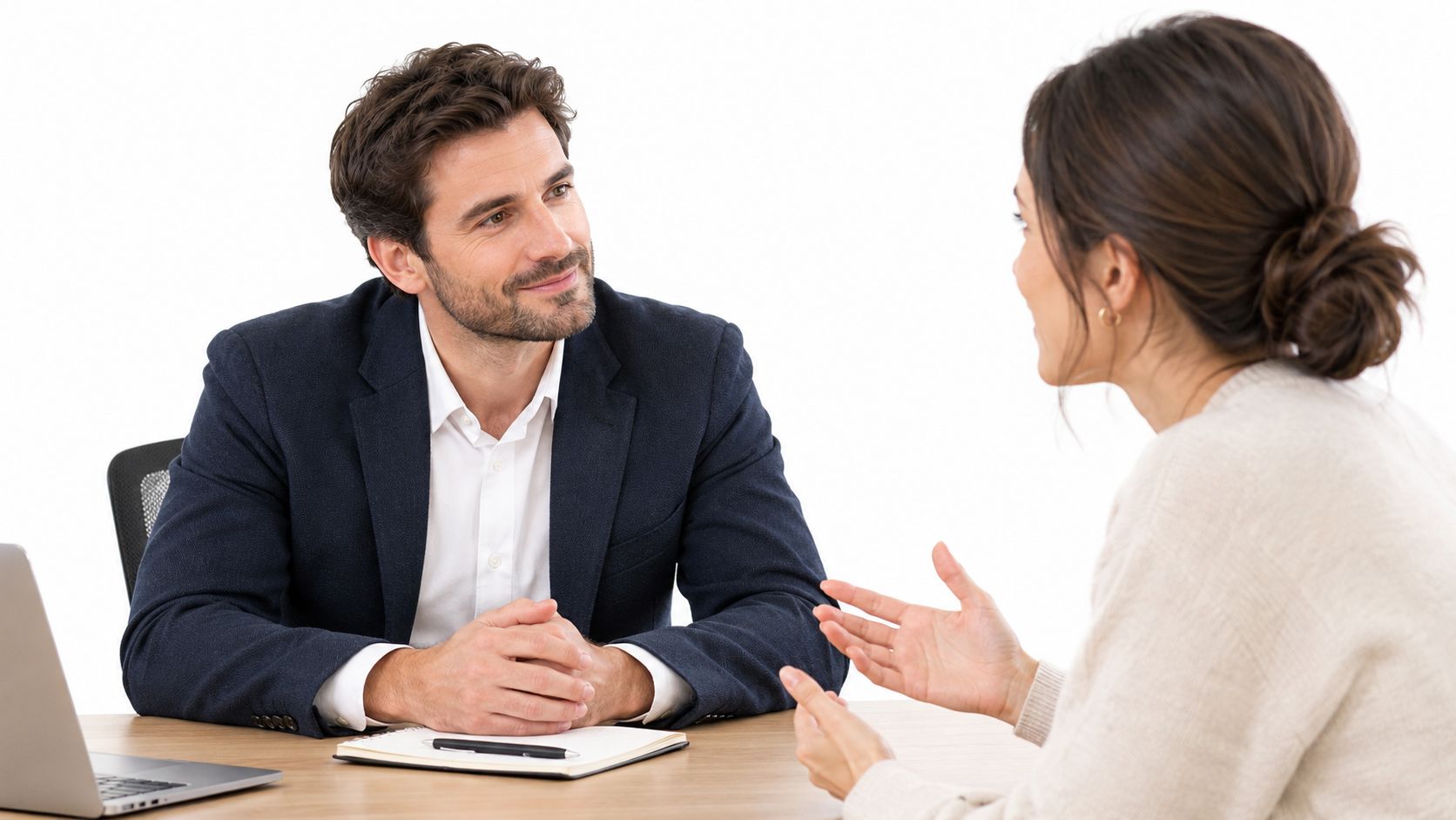 A professional man and woman having a productive conversation during a business meeting at an office desk.